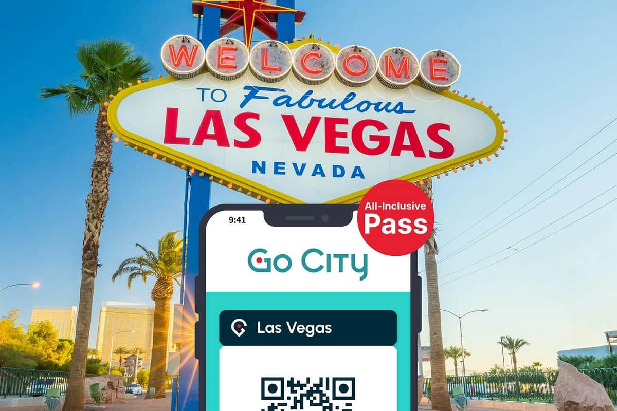 Les Vegas All-Inclusive Pass by Go City es mostra en un telèfon intel·ligent amb la cartellera de benvinguda de Las Vegas al fons