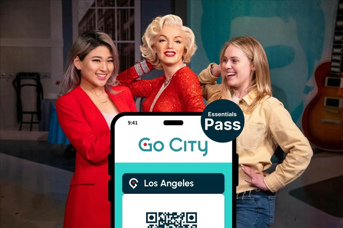 Trois femmes posant ensemble, dont l'une ressemble à Marilyn Monroe, avec un Pass « Go City Essentials » pour Los Angeles bien en évidence devant elles.