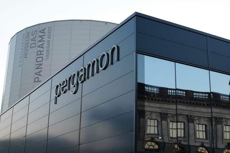 Pergamonmuseum. Das Panorama City Card (Berlin) Modern building with "Pergamon" signage, reflective windows, and a cylindrical structure in the background labeled "Pergamon Museum DAS PANORAMA."