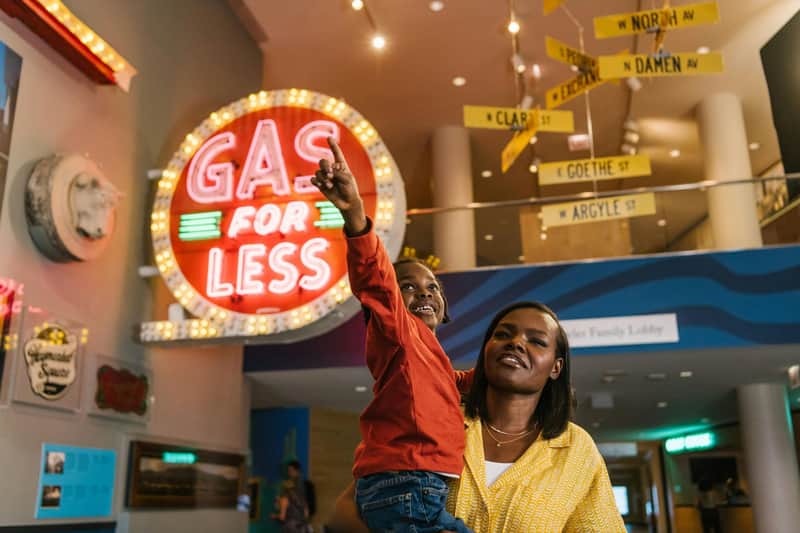 Photo of Museum Lobby. Young child in parent's arms, pointing up.