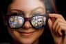 A smiling person wearing sunglasses showing reflections of various individuals, including animated and real characters.