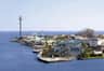 A coastal amusement park with a wooden roller coaster, Ferris wheel, observation tower, and various buildings.